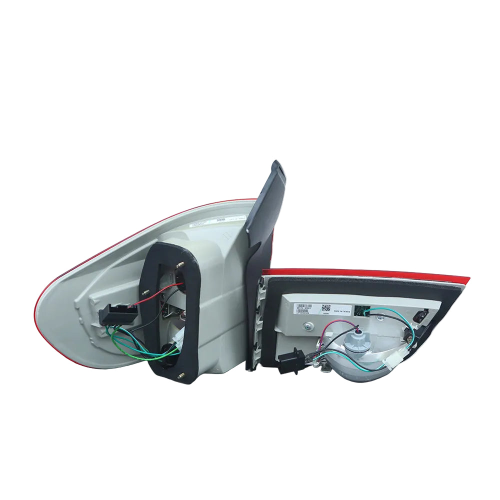 A rear-view side mirror assembly with the outer housing removed, showing the internal glass, wiring, and mounting hardware against a plain light gray wall.
